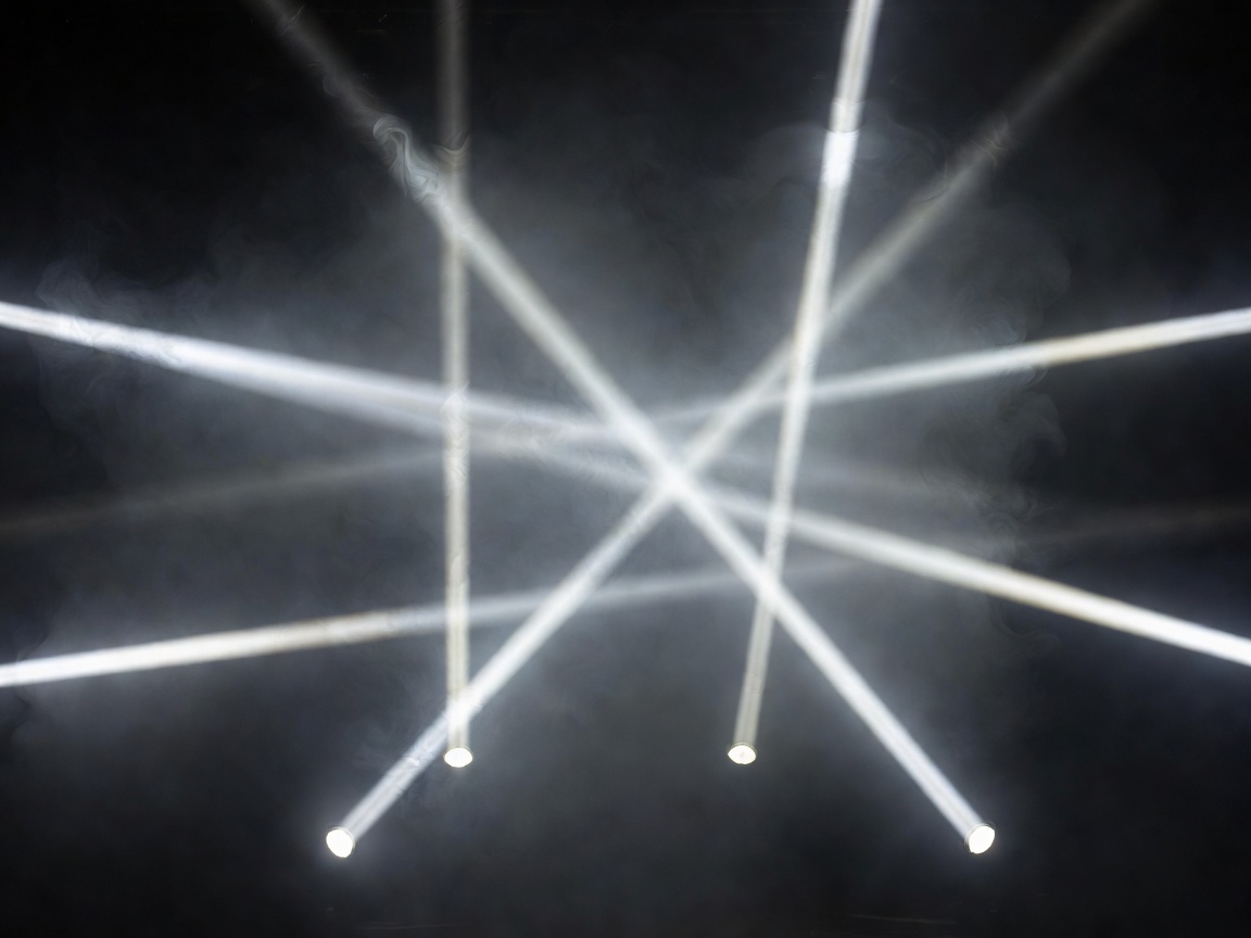 Narrow white stage beams forming intersecting lines in dark haze